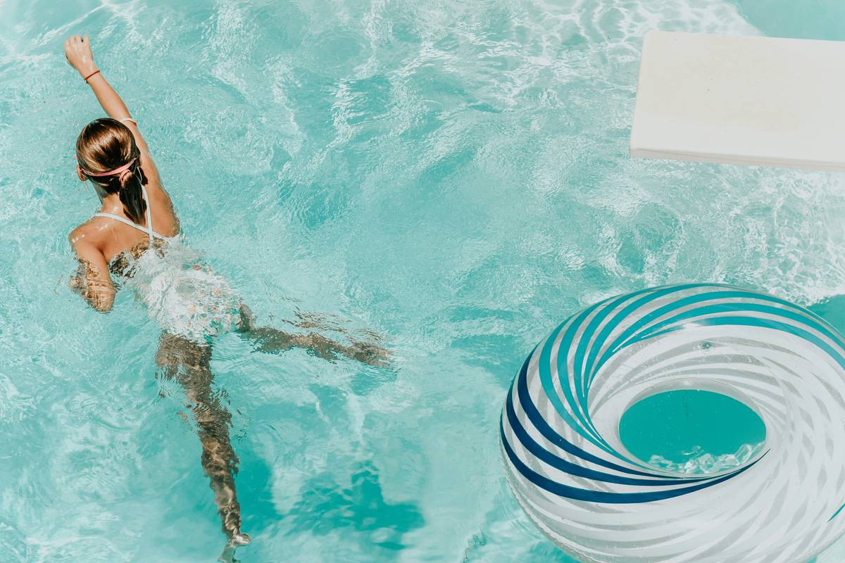 Woman practicing proper freestyle technique to find swimming benefits for health