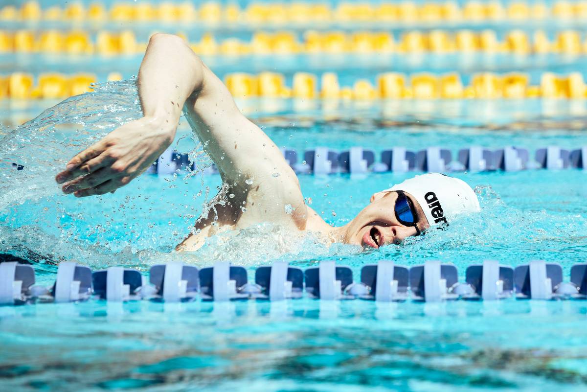 swimming skills and techniques demonstrated by an adult learner practicing freestyle stroke in a lap pool