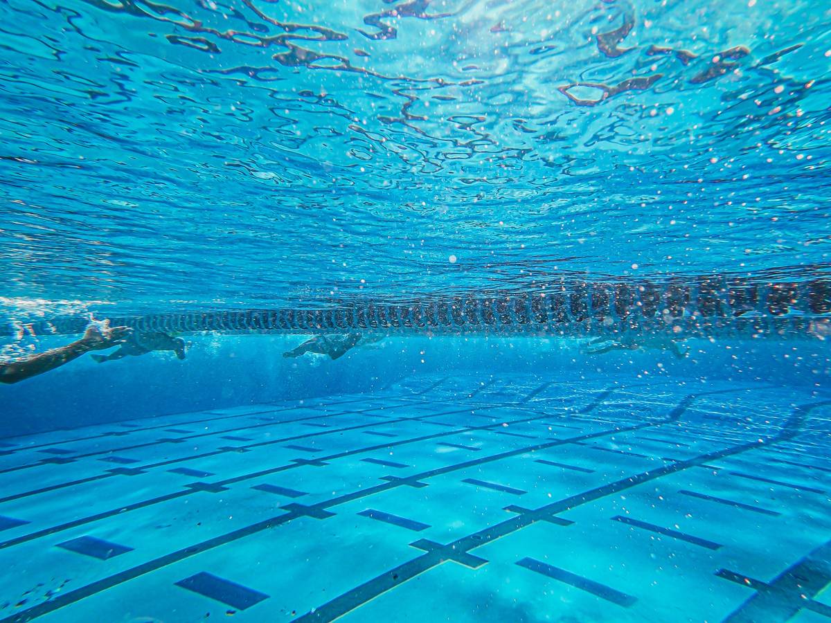Dryland gym exercises for swimming showing rotational core work with landmine press