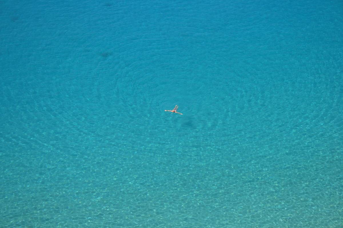 Woman experiencing surprising benefits of swimming through mindful floating in calm pool water