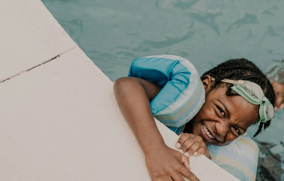 swimming techniques for kids demonstrating floating with a coach in a pool